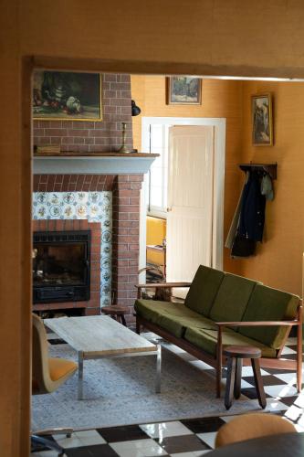 un salon avec un canapé et une cheminée dans l'établissement Maison Maa, Maison principale, à 5min de Saint-Valery-sur-Somme à pieds le long du canal, à Boismont