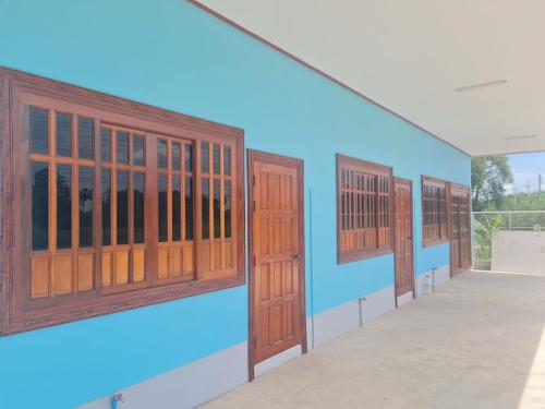 eine Reihe von Holztüren an einem Gebäude in der Unterkunft ทรัพย์แม่หนุน 