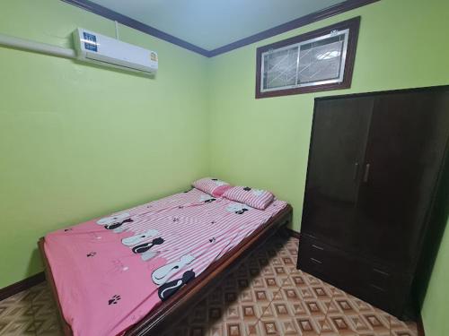 a bedroom with a pink bed and a cabinet at ทรัพย์แม่หนุน 