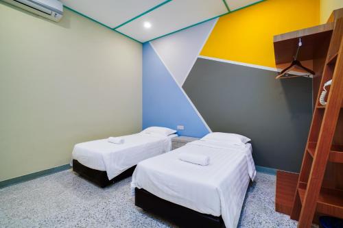two beds in a room with colorful walls at Dream & Wander Homestay in Ipoh