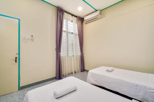 a room with two beds and a window at Dream & Wander Homestay in Ipoh