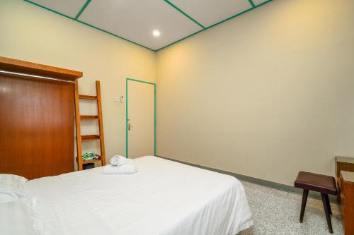 a bedroom with a white bed and a wooden cabinet at Dream & Wander Homestay in Ipoh