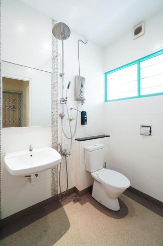 a white bathroom with a toilet and a sink at Dream & Wander Homestay in Ipoh