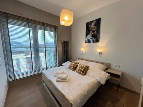 a bedroom with a bed and a large window at Apartament ZETA - CITY 2 in Ustroń