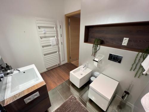 a bathroom with a white sink and a toilet at Apartament ZETA - CITY 2 in Ustroń