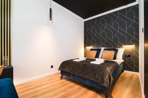a bedroom with a bed with a large headboard at Black Pearl Apartment starówka in Elblag