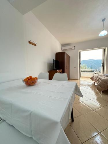 a white room with a table with a bowl of oranges on it at Villa Ani in Borsh
