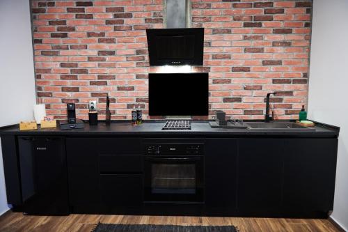 a kitchen with a black counter and a brick wall at The Skyline Suite in Florina
