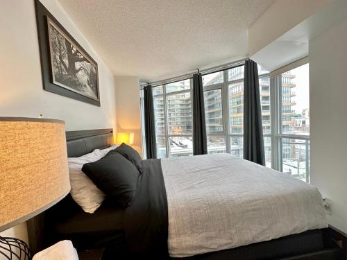 a bedroom with a bed and a large window at City Lake 2 Storey Condo in Toronto