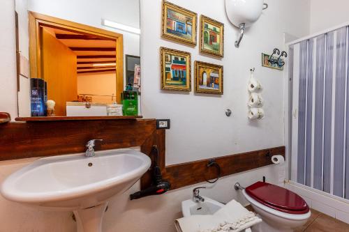 a bathroom with a sink and a toilet and a mirror at B&B Villa San Marco in Agrigento