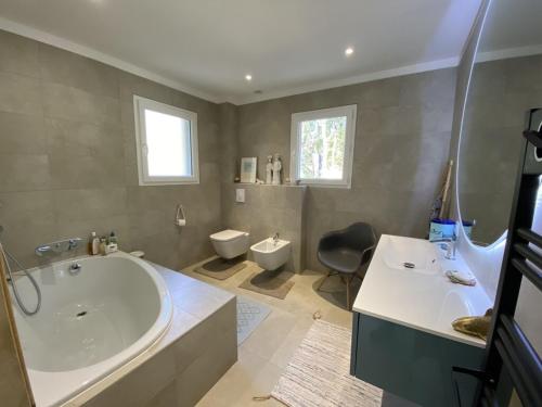 une salle de bain avec une baignoire, un lavabo et des toilettes dans l'établissement Villa Martine, à Nans-les-Pins