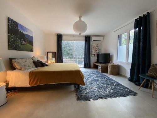 une chambre avec un lit et une grande fenêtre dans l'établissement Villa Martine, à Nans-les-Pins