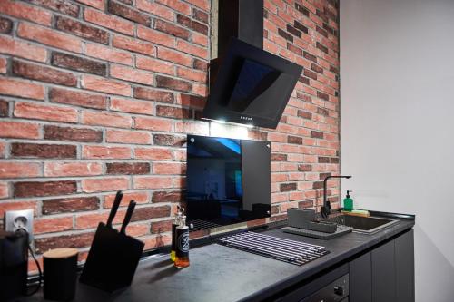 a brick wall with a television on top of a counter at The Skyline Suite in Florina