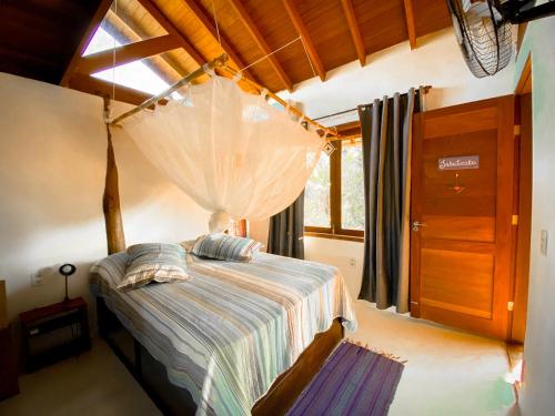 a bedroom with a bed with a mosquito net at CASA Ecológica Paraty in Paraty
