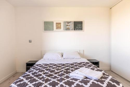 una camera da letto con un letto con due asciugamani sopra di Maison Piscine Zénith d'auvergne Clermont Sud a La Roche-Blanche