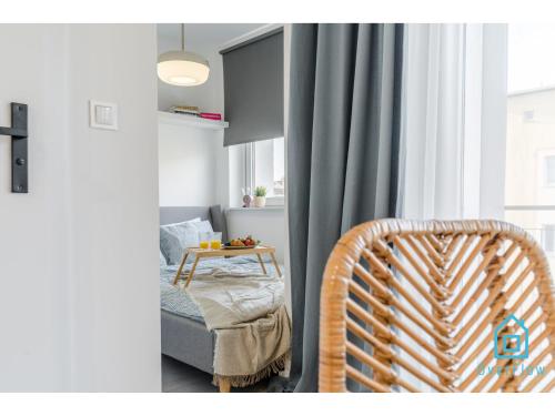 a room with a chair and a bed and a window at Shiny Apartment in Gdańsk