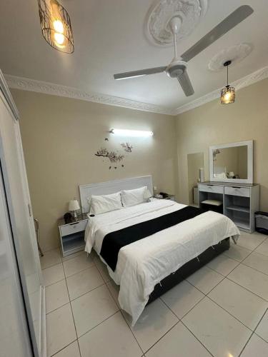een slaapkamer met een groot bed en een plafondventilator bij شاليهات هدوء الشاطئ لبيوت العطلات in Ar Rukūbah