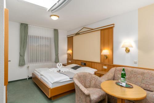 a hotel room with a bed and a table at BmB Vollersode Monteurzimmer / Pension in Vollersode