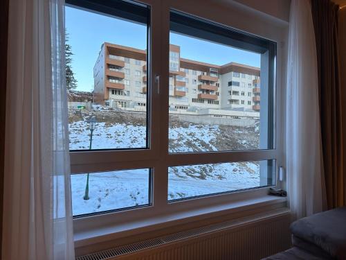 une fenêtre avec vue sur un bâtiment dans l'établissement Miyaki Apartments - BJELASNICA, à Bjelašnica