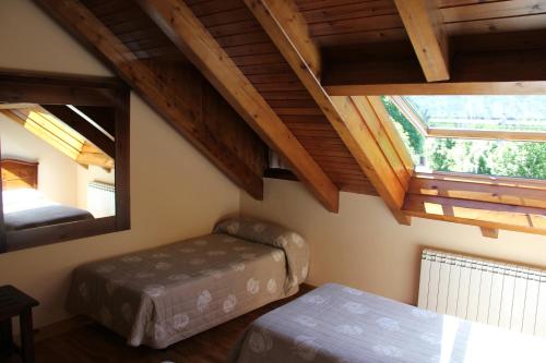 a attic room with two beds and a window at Hotel Rantiner in Taull