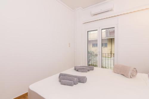 Cette chambre blanche dispose d'un lit et d'une fenêtre. dans l'établissement Two bedroom Apt near Hilton, à Athènes