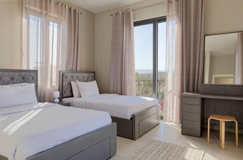 a hotel room with two beds and a mirror at Vesta - El Gouna Residence in Hurghada
