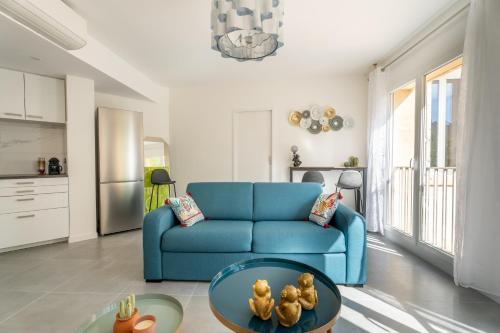 un salon avec un canapé bleu et une table dans l'établissement Modernity & Comfort Downtown Aix en Provence, à Aix-en-Provence