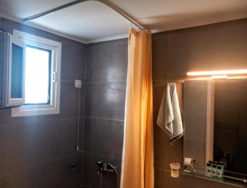 a bathroom with a shower and a shower curtain at Evgenia Rooms in Skala