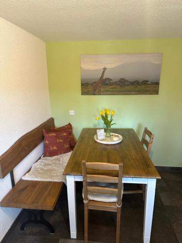 a dining room with a table and a giraffe painting at Appartement Maasai Mara mit Whirlpool und Sauna in Bad Saulgau