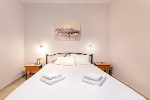 ポリフロノにあるMaria Roomsのベッドルーム1室(白い大型ベッド1台、テーブル2台付)