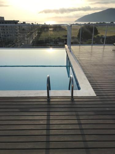 a swimming pool with a ramp next to the water at Ubatuba Encantador in Ubatuba