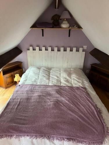 - une chambre avec un lit blanc et une couverture violette dans l'établissement La Bergerie, à Plouha