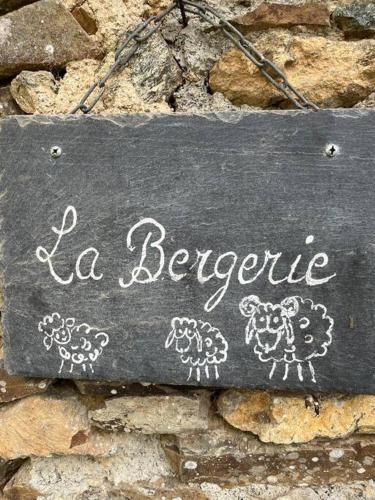 un cartel que dice "La bergerle" con ovejas pintadas en él. en La Bergerie, en Plouha