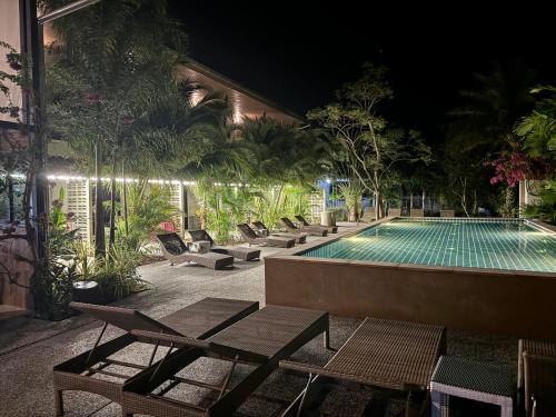 a swimming pool with lounge chairs next to a building at aonangstudio 2 floor in Klong Muang Beach
