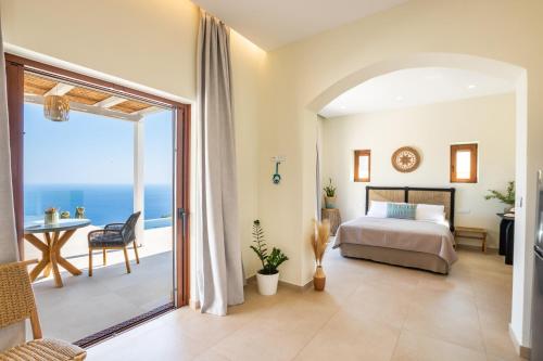 a bedroom with a bed and a view of the ocean at MerTelia Luxury Villas in Kyra Panagia