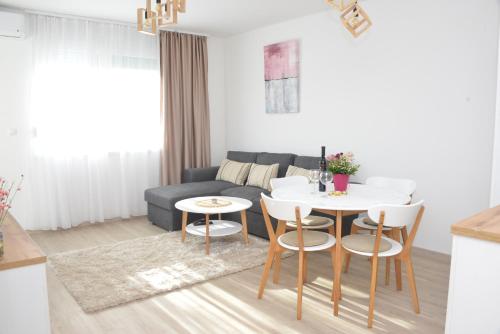 uma sala de estar com um sofá, uma mesa e cadeiras em Bella em Sremska Mitrovica