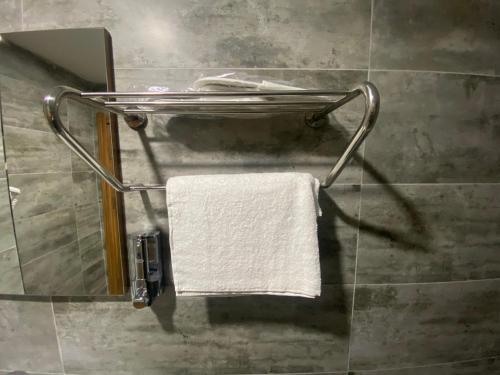 - Baño con toallero eléctrico y toalla blanca en Rosse Hotel en Esenyurt