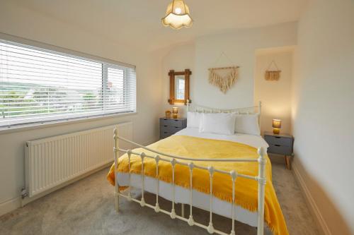 a bedroom with a bed and a large window at Hillside View Staithes in Staithes