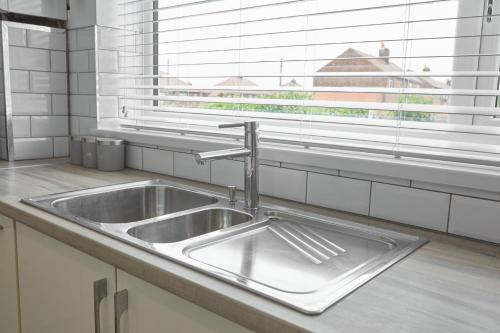 a stainless steel sink in a kitchen with a window at Hillside View Staithes in Staithes