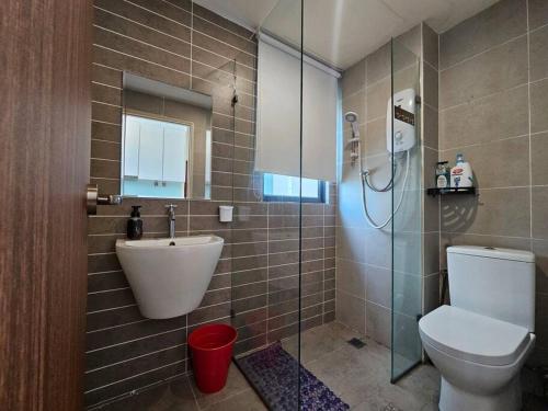 a bathroom with a toilet and a sink and a shower at Kozi Square comfort Studio Home 2D in Kuching