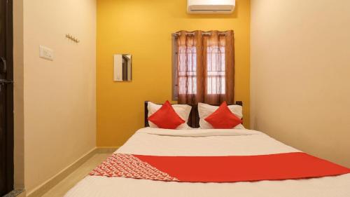 łóżko z czerwonymi poduszkami w pokoju w obiekcie Hotel Park Sivagangai w mieście Sivaganga