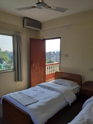 um quarto com 2 camas e uma janela com uma varanda em Hotel Vibe by Solitary em Pokhara