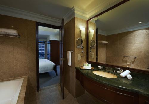 baño con lavabo, espejo y cama en Comel Service Suite at Times Square, en Kuala Lumpur