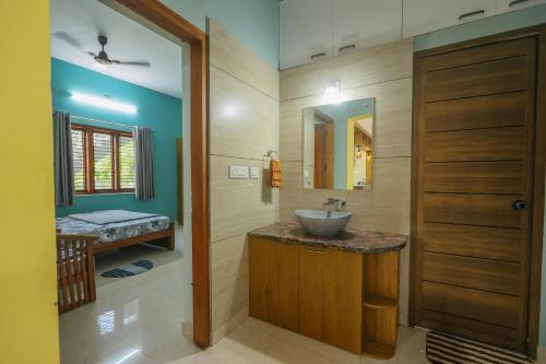 a bathroom with a sink and a mirror at Padma Bliss Guest House in Mangalore