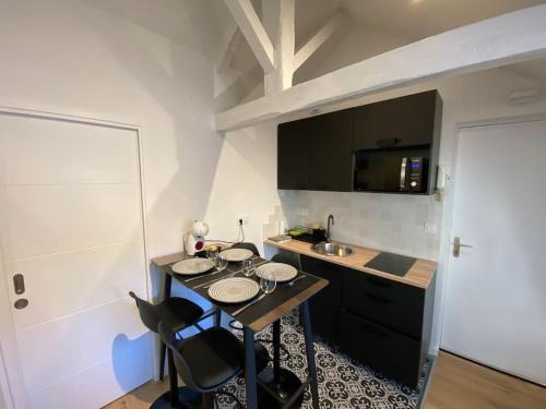 une petite cuisine avec une table et un évier dans l'établissement Appartement - Le cocon Rémois, à Reims