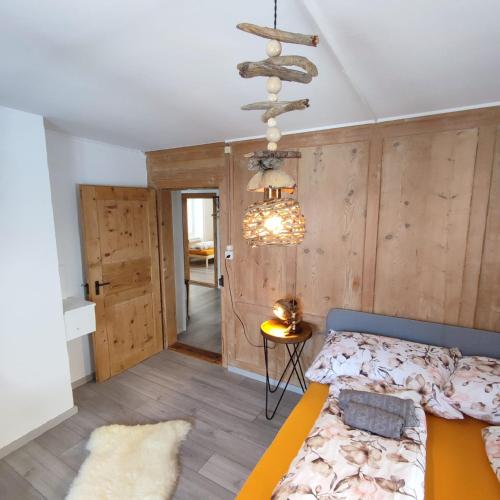- une chambre avec un lit et un lustre dans l'établissement Haus Albula, à Alvaneu
