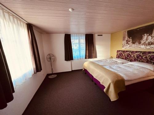 a bedroom with a large bed and a fan at Gasthaus Sternen in Rafz