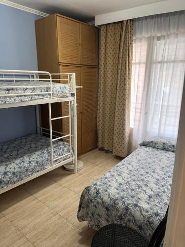 1 dormitorio con 2 literas y ventana en Residencia Alclausell, en Tarragona