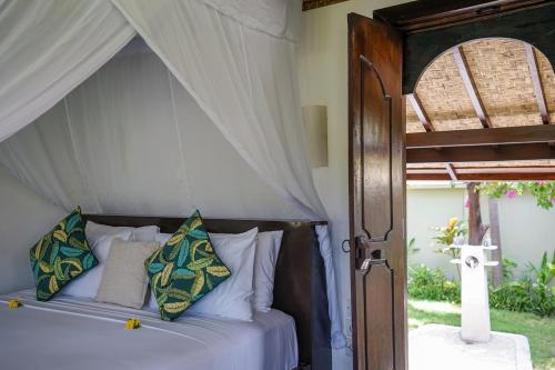 a bedroom with a bed with a canopy at Pondok Santi Estate in Gili Trawangan