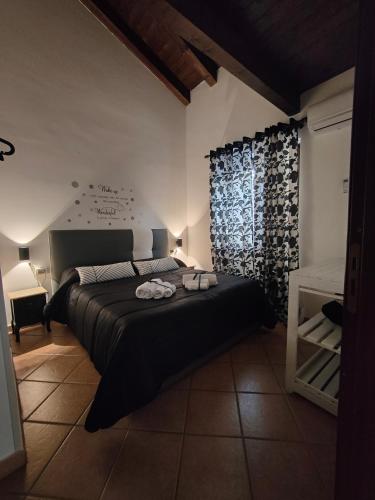 a bedroom with a large black bed and a window at Casa Palazzo Reale in Palermo